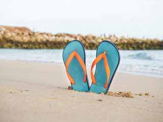 Colorful flip flops on the sandy beach