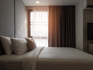 Obraz premium Interior of cozy bedroom in modern design.low lighting and Lens flair in sunlight.