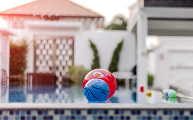 Colorful beach balls floating in a resort pool
