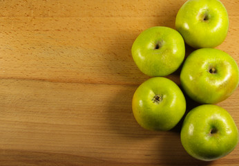 Fresh green apples on wooden background