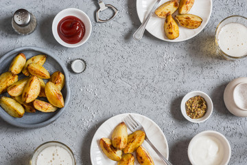 Frame with baked potatoes, beer and sauces. Top view. Free space for text