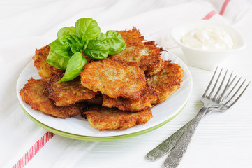 Plate of potato pancakes with basil leaves