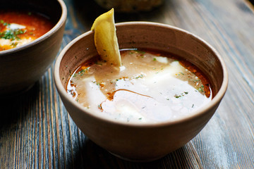 Solyanka,traditional Russian dishes, soup broth of smoked. Wooden background. 