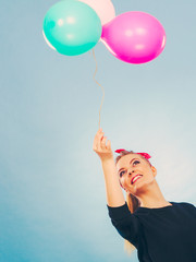 Lovely smiling girl holds colorful balloons.