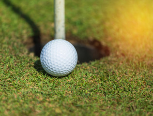 / golf ball near the hole on green grass
