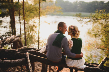 Romantic couple sitting on the roots  the sunset background