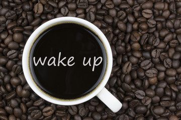 wake up text in coffee cup on coffee beans background