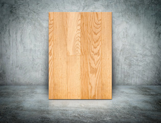 Blank wood block frame leaning at grunge grey concrete wall and