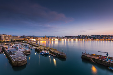 Naklejka premium Illuminated port in San Sebastian at evening twilight