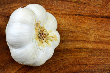 Hintergrundbild für Gewürzkarte - Knoblauchzwiebel am Holztisch mit Textfreiraum