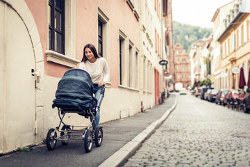 Young Mother With Baby Stroller In The City