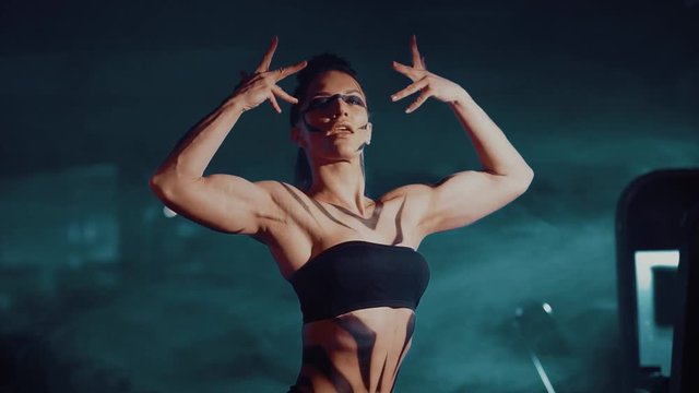 female fitness model flexes her muscles and shows her body in the pose