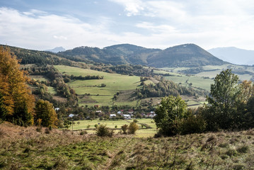 autumn landscape of Kysuce region in Slovakia with Horny Vadicov village, meadows, fields, hills and blue sky with clouds