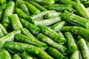 Wet fresh green french bean in water  closeup as background. Healthy vitamin food.