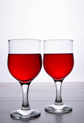 glass of red wine. A couple of glasses of wine on a light wooden background