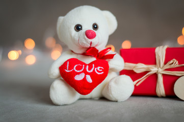 Teddy bear with a heart on the background lights for Valentine's day
