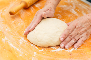 Woman cooks dough on table