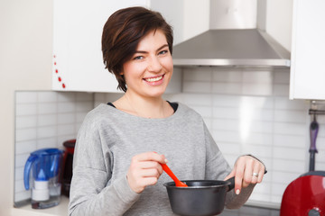 Woman with saucepan and spoon