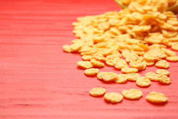 Corn flakes on red wooden background