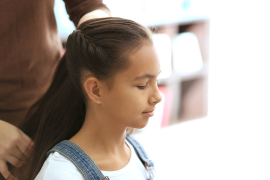 Woman Doing Hair Of Her Daughter At Home, Closeup