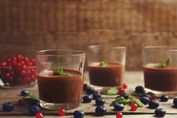 Chocolate mousse in glasses on wooden background