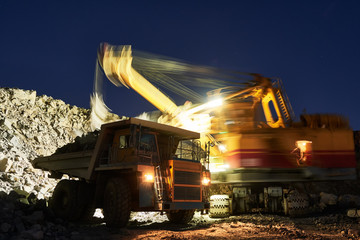 Mining. excavator loading granite or ore into dump truck © Kadmy