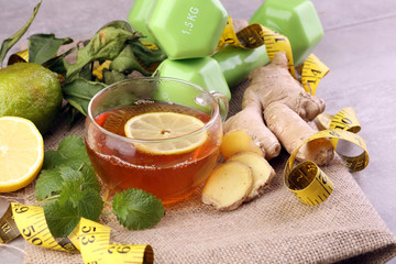 ginger tea - fitness liefestyle concept with tea, dumbells and measure tape - Healthy tea detox