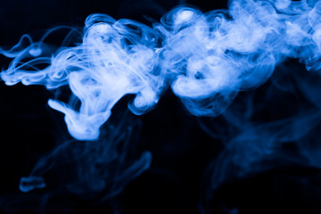 Cloud of smoke on black background. Selective focus. Toned