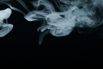 Fototapeta premium Cloud of smoke on black background. Selective focus. Toned