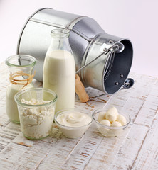 milk products - tasty healthy dairy products on a table on: sour cream in a white bowl, cottage cheese bowl, cream in a a bank and milk jar, glass bottle and in a glass