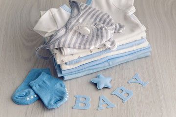 baby clothes with diapers are stacked on a wooden table with the letters baby and little star