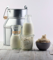 milk products - tasty healthy dairy products on a table on: sour cream in a white bowl, cottage cheese bowl, cream in a a bank and milk jar, glass bottle and in a glass