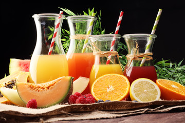 Apple and orange juice -several bottles with fruit and berry juices, vintage wooden background, selective focus
