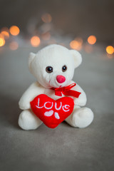 Teddy bear with a heart on the background lights for Valentine's day
