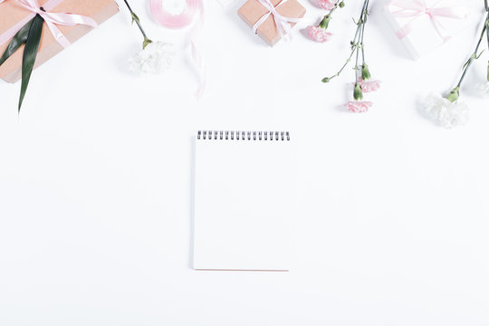 Festive composition: notebook, boxes with gifts, ribbons and flo