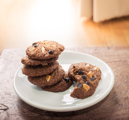 Chocolate chip cookies in white dish on wooden table.