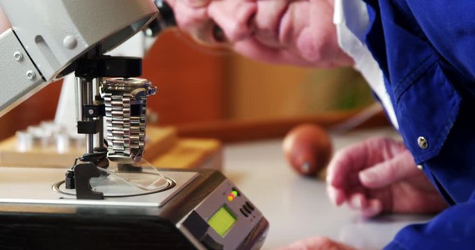 Horologist placing a watch on a machine