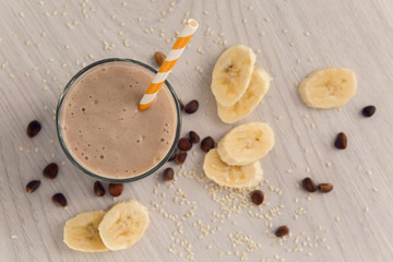 banana smoothie in a glass with a straw