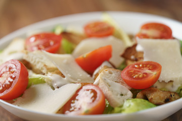 closeup photo of fresh made caesar salad with cherry tomatoes, shallow depth of field