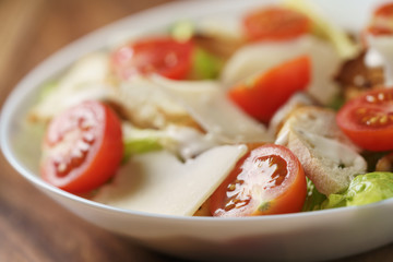 closeup photo of fresh made caesar salad with cherry tomatoes, shallow depth of field