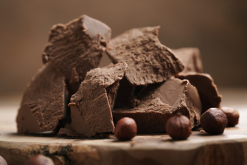 chunks of gianduja with hazelnuts on wood board, premium chocolate dessert