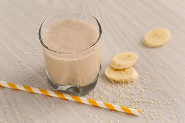 banana smoothie in a glass with a straw