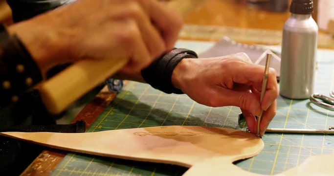 Close-up of craftswoman nailing leather