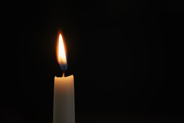 tall candle blown in the dark environment, shallow focus