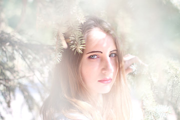 Portrait of a young woman in the spruce branches