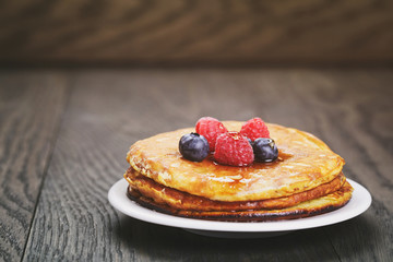 fresh homemade pancakes with berries and maple syrup, slightly toned photo