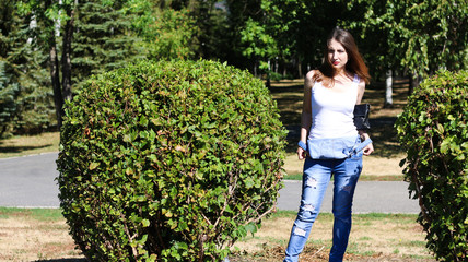 Woman take off the overalls next to a big Bush