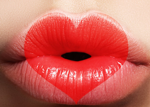 Valentine Heart on beautiful female Lips. Sweet Kiss. Love Makeup for Valntines Day. Cute Shape Heart like Symbol of Love. Celebrate Lip Make-up on macro shoot