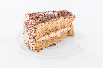 Chocolate cake slice with curl on white dish