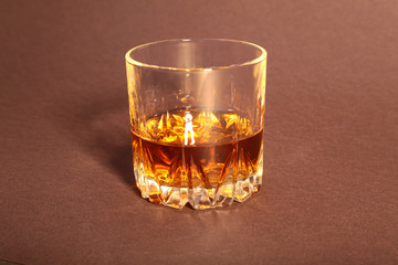 White cup of coffee and cognac in a glasses, pralines on red background.